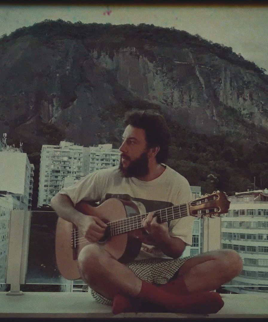 Pedro Mann na sacada de sua casa, no rio de janeiro, tocando violão