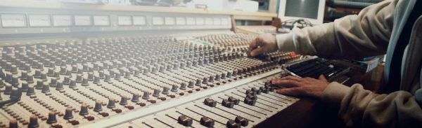 Produtor musical trabalha na mesa de som em estúdio