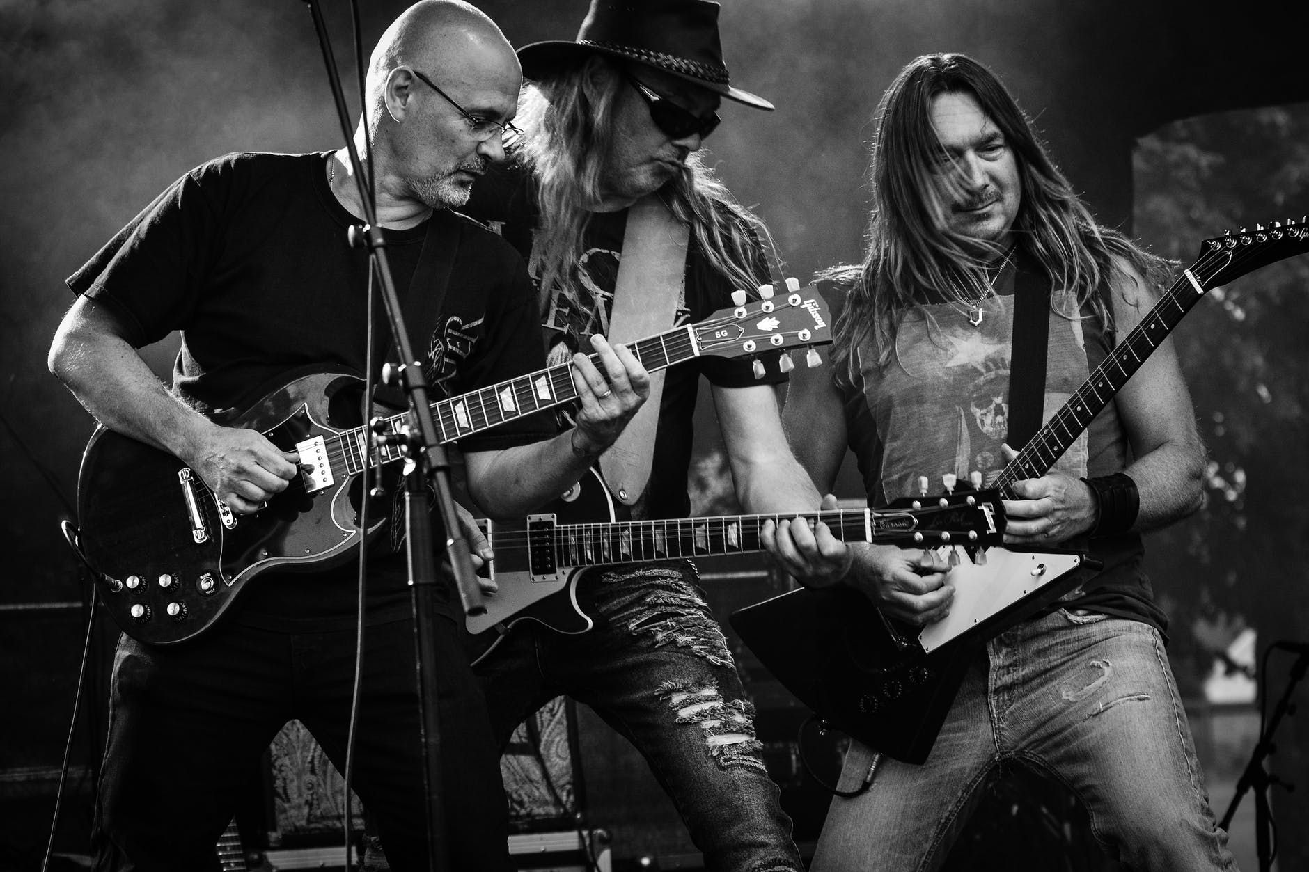 Três guitarristas de uma banda de rock fazendo um som ao vivo