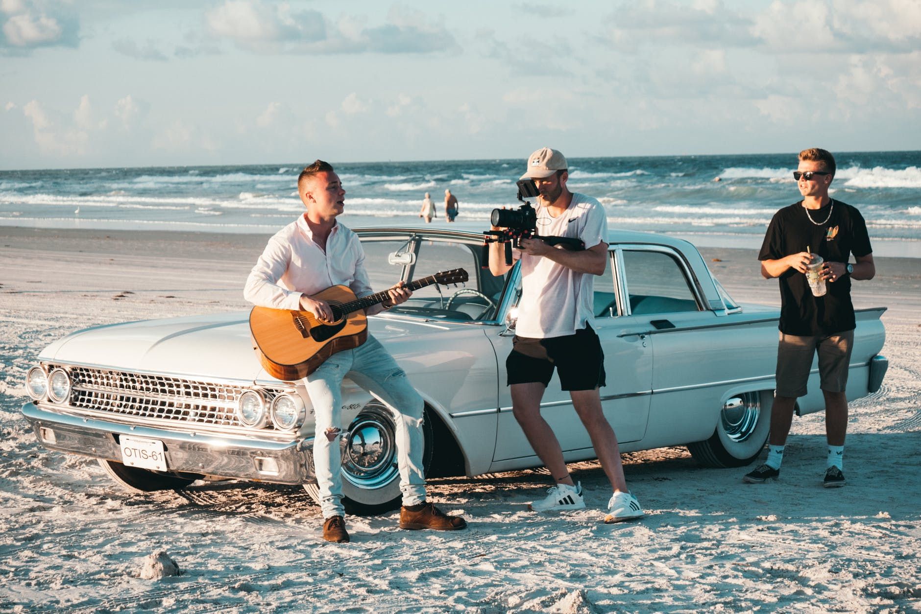 Músico grava vídeo tocando violão na praia